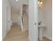 Bright entryway with wood-look floors, a staircase with a dark metal handrail, and a pedestal sink at 1266 Langston Ln, Salisbury, NC 28144