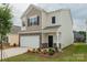 Charming two-story home with a two-car garage, manicured lawn, stone accents and neutral colored siding at 1266 Langston Ln, Salisbury, NC 28144