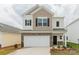 Two-story home features a two-car garage, stone accents, neutral siding, and a well manicured lawn at 1266 Langston Ln, Salisbury, NC 28144