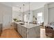 Spacious kitchen featuring an oversized island with bar seating, stainless appliances, and hardwood floors at 1315 East Blvd # 225, Charlotte, NC 28203