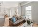 Bright living room features hardwood floors, large windows, and comfortable leather sofa with stylish pillows at 1315 East Blvd # 225, Charlotte, NC 28203