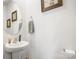 Cozy half-bathroom features a pedestal sink and decorative wall art at 1343 Kent Downs Sw Ave, Concord, NC 28027