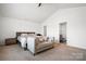 Bright bedroom with queen bed, sofa, and an ensuite bathroom through a door at 1343 Kent Downs Sw Ave, Concord, NC 28027