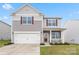 Charming two-story home with a manicured lawn, inviting porch, and attached garage at 1343 Kent Downs Sw Ave, Concord, NC 28027