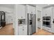 Kitchen area with stainless steel refrigerator, white cabinetry, and view into adjacent rooms at 1532 Gossage Nw Ln, Concord, NC 28027