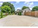 Spacious home featuring a large driveway, lush lawn, mature trees, and a wood privacy fence at 157 Downey Lake Rd, Dallas, NC 28034