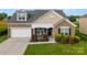 Charming brick home with a manicured lawn, attached garage, and inviting front porch and well landscaped beds at 163 Sassafras Rd, Mooresville, NC 28115