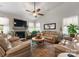 Spacious living room with a fireplace, TV, plush sofas, and a ceiling fan for relaxation and entertainment at 163 Sassafras Rd, Mooresville, NC 28115