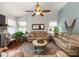 Bright living room featuring plush sofas, a ceiling fan, and large windows offering plenty of natural light at 163 Sassafras Rd, Mooresville, NC 28115