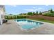 Beautiful in-ground pool surrounded by lush landscaping, including mature trees, shrubs, and green grass at 163 Sassafras Rd, Mooresville, NC 28115