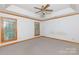 Spacious bedroom featuring neutral carpet, white trim, a ceiling fan, and natural light from two windows at 1636 Springwinds Dr, Rock Hill, SC 29730