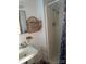 Compact bathroom featuring a white shower stall, sink, and wicker storage at 177 Mountain View Ln, Troy, NC 27371