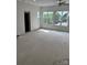 Spacious living room with multiple windows and a doorway, showcasing potential for renovation at 177 Mountain View Ln, Troy, NC 27371