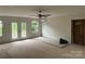Spacious living room featuring French doors, windows, and a ceiling fan for natural light at 177 Mountain View Ln, Troy, NC 27371