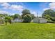 Expansive backyard with a detached garage, surrounded by mature trees, under a blue sky at 2000 Townsend Ave, Charlotte, NC 28205