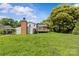 Expansive lawn and rear-house deck and chimney with a backdrop of privacy trees at 2000 Townsend Ave, Charlotte, NC 28205