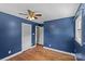Bedroom with dark blue walls, hardwood floors, white trim, and a ceiling fan at 2000 Townsend Ave, Charlotte, NC 28205