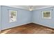 Bright bedroom featuring hardwood floors, a ceiling fan, and two windows at 2000 Townsend Ave, Charlotte, NC 28205