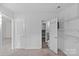 Bedroom showing the door to the bathroom with white walls, carpet flooring, and built-in storage shelves at 2000 Townsend Ave, Charlotte, NC 28205