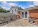 Wide angle view of the wood deck leading to double glass doors and the brick-sided house beneath blue skies at 2000 Townsend Ave, Charlotte, NC 28205