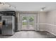 Kitchen area with gray tile floor and silver fridge leading to french doors to the deck at 2000 Townsend Ave, Charlotte, NC 28205