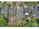 Drone shot showcases an appealing backyard, including a brick firepit and lush landscaping at 202 Caldwell Ln, Davidson, NC 28036
