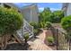 Landscaped backyard featuring a staircase, lush greenery, and a brick walkway at 202 Caldwell Ln, Davidson, NC 28036