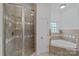 Bathroom featuring tiled shower, separate bathtub, and neutral color scheme at 202 Caldwell Ln, Davidson, NC 28036