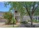 Inviting home with double porches, brick accents, and mature trees offering shade and enhancing its outdoor charm at 202 Caldwell Ln, Davidson, NC 28036