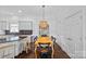 Open kitchen view with island, dining area, hardwood floors, and white cabinetry at 202 Caldwell Ln, Davidson, NC 28036