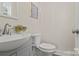 Elegant half bathroom featuring a pedestal sink and a modern toilet at 203 Putnam St, Shelby, NC 28152