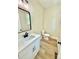 Stylish half bathroom featuring a modern vanity, black faucet, a mirror and vinyl flooring at 203 Putnam St, Shelby, NC 28152