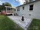 Paver patio leads to a screened in porch with steps up, white exterior with a brick accent at 2115 Arnold Dr, Charlotte, NC 28205