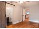Bedroom with modern fixtures, wood door to a bathroom with a dark vanity, and hardwood floors at 2115 Arnold Dr, Charlotte, NC 28205