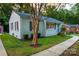 Charming white brick home featuring a lush green lawn, walkway, and mature trees, offering delightful curb appeal at 2115 Arnold Dr, Charlotte, NC 28205
