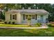 Charming single-story home featuring a light blue front door, gray shutters, and lush, green landscaping at 2115 Arnold Dr, Charlotte, NC 28205