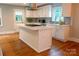 Bright kitchen with a center island, white cabinets, hardwood floors, and modern stainless-steel appliances at 2115 Arnold Dr, Charlotte, NC 28205