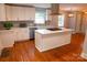 Bright kitchen with a center island, white cabinets, hardwood floors, and modern stainless-steel appliances at 2115 Arnold Dr, Charlotte, NC 28205