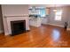 Spacious living room showcasing hardwood floors, a fireplace, and an open layout connecting to the kitchen at 2115 Arnold Dr, Charlotte, NC 28205