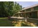 Home's back exterior featuring a patio and a well-maintained lawn surrounded by mature trees at 215 W Eastway Drive Dr, Charlotte, NC 28213