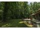 Picturesque backyard featuring mature trees, a brick patio, and a green home exterior at 215 W Eastway Drive Dr, Charlotte, NC 28213