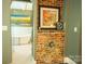 An entrance to a bright bathroom featuring a standalone tub, glass shower, and an alcove with a brick facade at 215 W Eastway Drive Dr, Charlotte, NC 28213