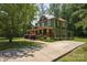 A two-story home displays its green exterior, complemented by a concrete driveway at 215 W Eastway Drive Dr, Charlotte, NC 28213
