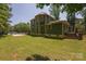 Green two-story home boasts a spacious yard, a concrete pad, and mature trees at 215 W Eastway Drive Dr, Charlotte, NC 28213
