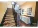 Inviting foyer showcases hardwood floors, a carpeted staircase, and a decorative table with historical displays at 215 W Eastway Drive Dr, Charlotte, NC 28213