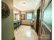 Hallway featuring hardwood floors, a wet bar, and a view into another room, blending design and functionality at 215 W Eastway Drive Dr, Charlotte, NC 28213