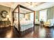 Spacious main bedroom with a four-poster bed, hardwood floors, and neutral accents create a relaxing retreat at 215 W Eastway Drive Dr, Charlotte, NC 28213