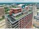 Aerial view of a modern building with rooftop amenities and stunning cityscape backdrop at 222 S Caldwell St # 2203, Charlotte, NC 28202