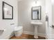 Elegant powder room featuring a pedestal sink, patterned walls, and sophisticated fixtures at 222 S Caldwell St # 2203, Charlotte, NC 28202