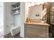 Modern bathroom featuring a sleek toilet, storage shelves, a floating vanity, and stone flooring at 222 S Caldwell St # 2203, Charlotte, NC 28202